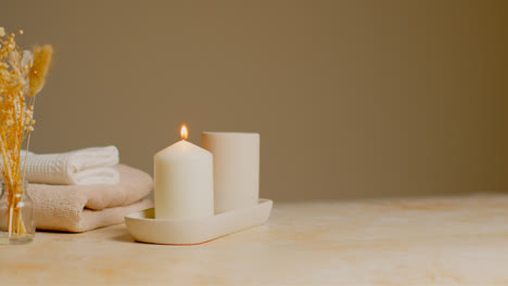 Still-Life-Of-Lit-Candle-With-Dried-Grasses-And-Soft-Towels-As-Part-Of-Relaxing-Spa-Day-Decor-3